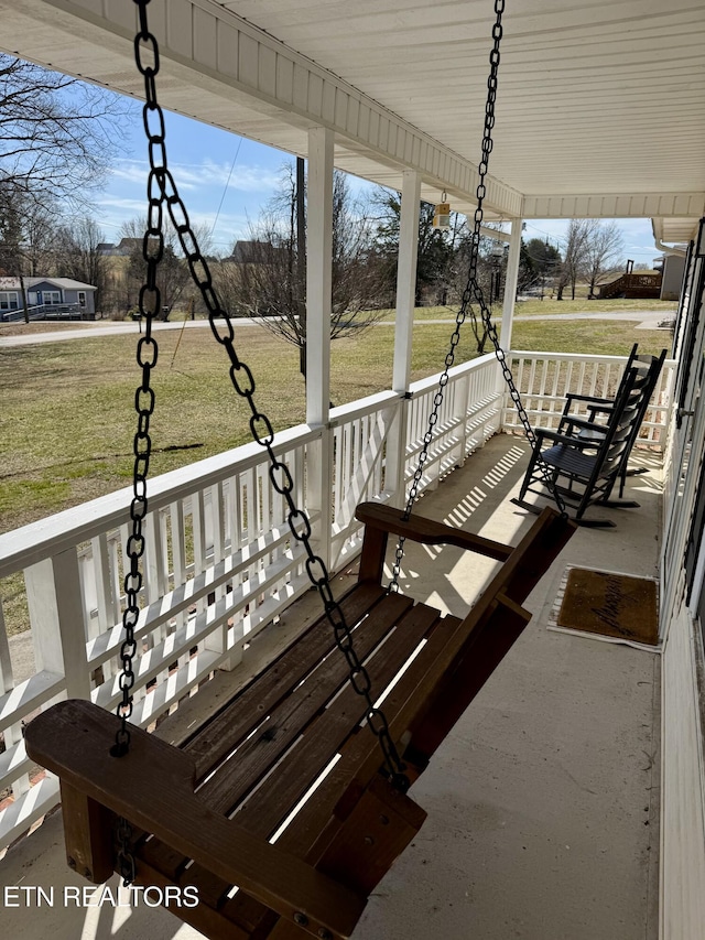 wooden terrace featuring covered porch and a yard