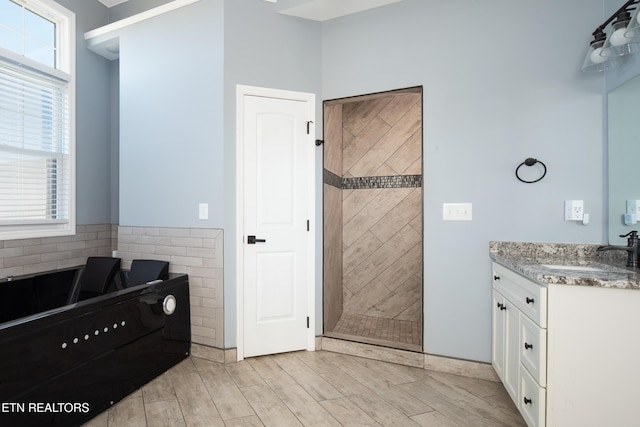 full bath with vanity, wood finish floors, a shower stall, and a wealth of natural light