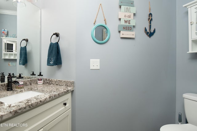 bathroom featuring crown molding, vanity, and toilet