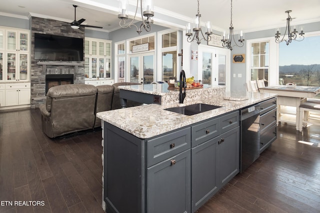 kitchen featuring crown molding, a stone fireplace, a sink, and french doors