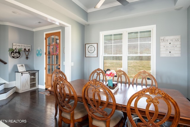 dining space featuring dark wood-style flooring, crown molding, visible vents, baseboards, and stairs