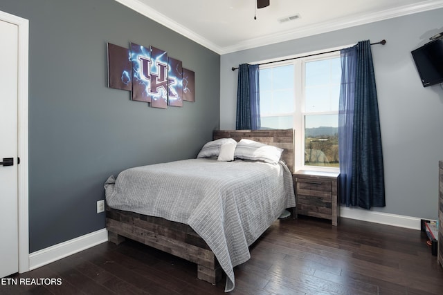 bedroom featuring crown molding, visible vents, ceiling fan, baseboards, and hardwood / wood-style flooring