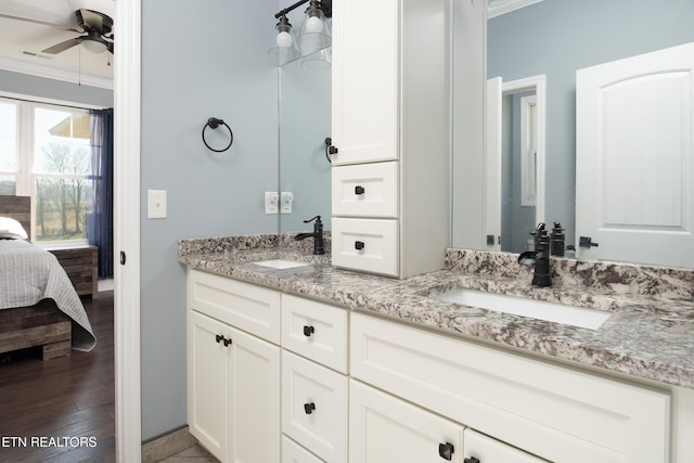 full bathroom featuring connected bathroom, wood finished floors, a sink, and ornamental molding