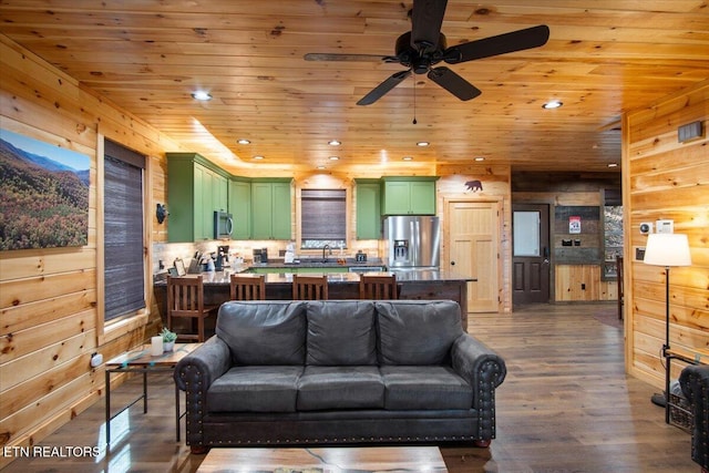 living room featuring dark wood finished floors, wood ceiling, wood walls, and recessed lighting