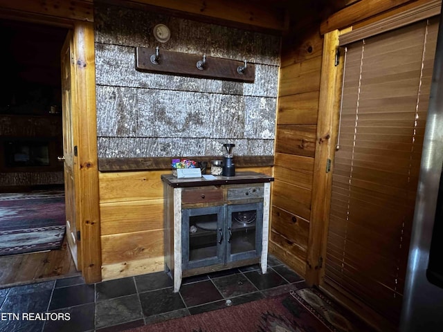 bar featuring stone tile flooring and wooden walls