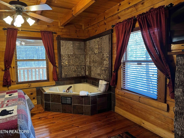 bathroom featuring a bath, wooden walls, beam ceiling, and hardwood / wood-style floors