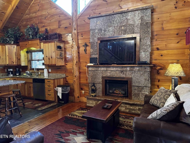 living area featuring lofted ceiling, wooden ceiling, hardwood / wood-style flooring, wooden walls, and a fireplace