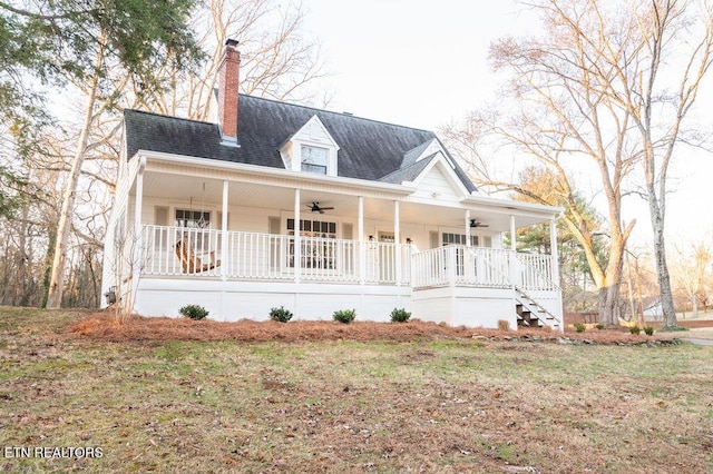 farmhouse with ceiling fan, a porch, roof with shingles, and a chimney