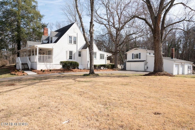 exterior space with a garage, a chimney, a porch, and a front yard