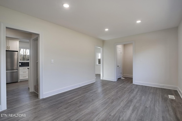 spare room with dark wood finished floors, recessed lighting, and baseboards