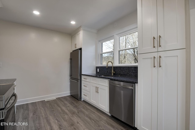 kitchen featuring white cabinets, dark wood-style flooring, appliances with stainless steel finishes, and a sink