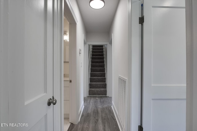 hallway with stairway, wood finished floors, and visible vents