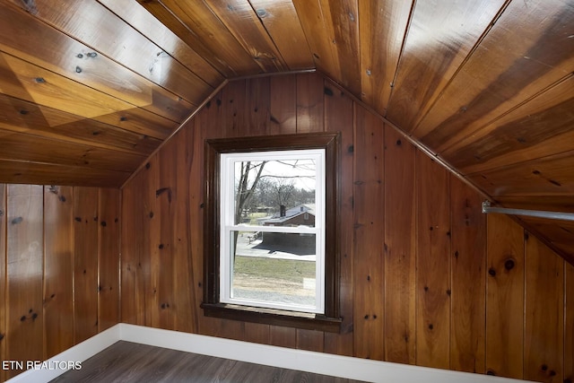 bonus room featuring wooden walls, wood finished floors, baseboards, vaulted ceiling, and wood ceiling