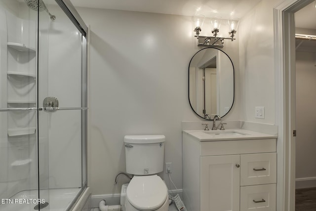 full bath featuring vanity, a shower stall, toilet, and baseboards