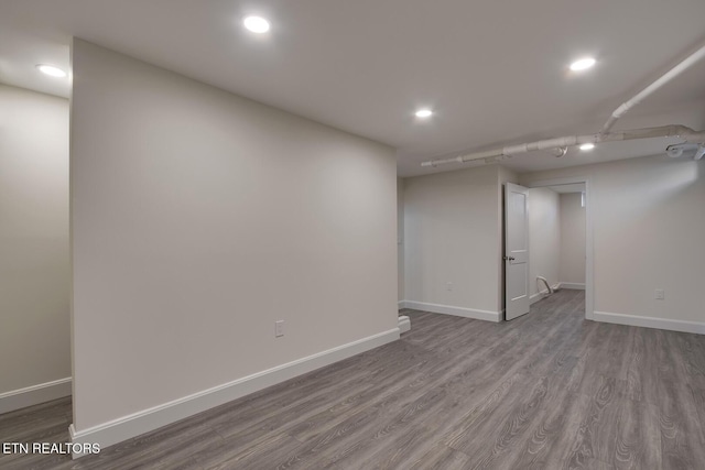 finished below grade area with recessed lighting, baseboards, and wood finished floors