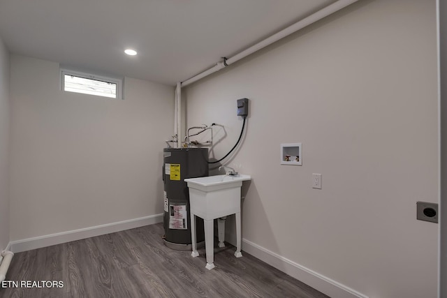 laundry area with baseboards, washer hookup, water heater, laundry area, and hookup for an electric dryer