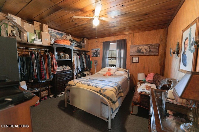 bedroom featuring carpet, wooden ceiling, and wood walls