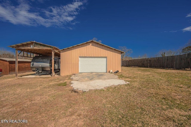 garage featuring driveway, a garage, and fence