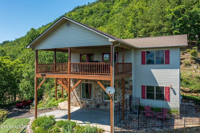 954 Pawnee Ct, Sevierville, TN 37876 - view of front of house with a patio, a shingled roof, and a forest view