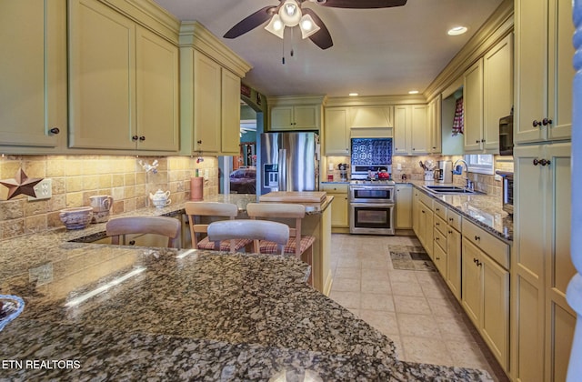 954 Pawnee Ct, Sevierville, TN 37876 - kitchen featuring ceiling fan, a sink, decorative backsplash, stainless steel appliances, and dark stone counters