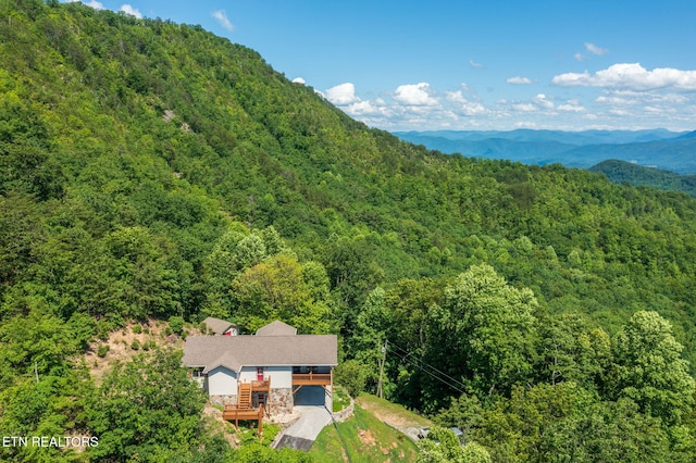 birds eye view of property featuring a mountain view and a view of trees