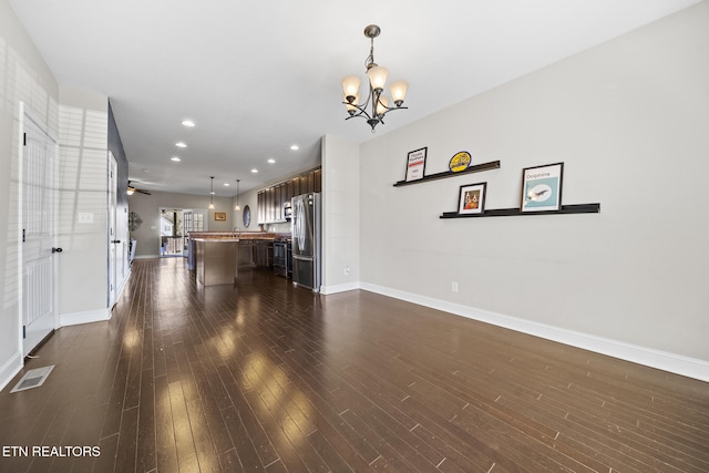 unfurnished living room with baseboards, visible vents, dark wood finished floors, and recessed lighting