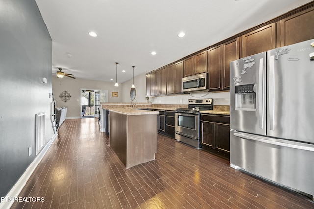 kitchen with dark wood-style floors, visible vents, appliances with stainless steel finishes, dark brown cabinetry, and an island with sink