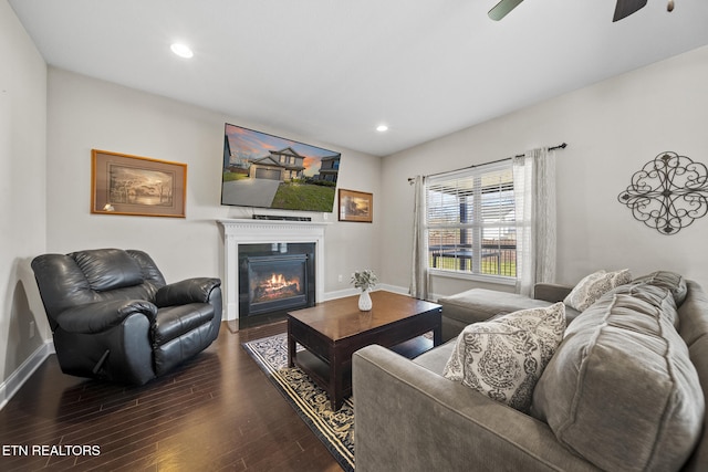 living area with baseboards, a glass covered fireplace, wood finished floors, and recessed lighting