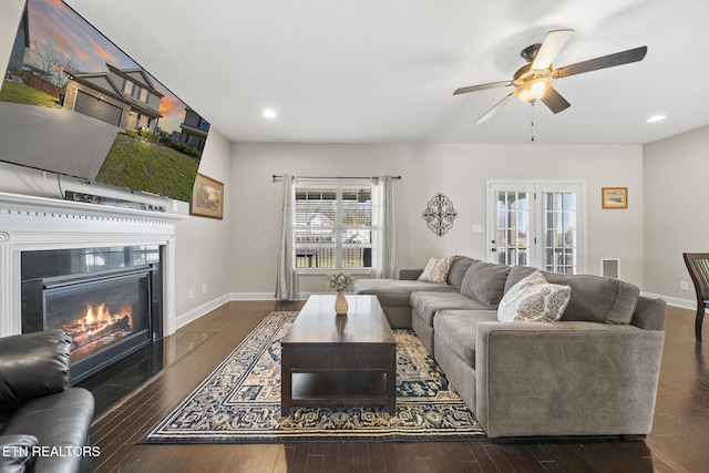 living room featuring hardwood / wood-style flooring, recessed lighting, baseboards, french doors, and a glass covered fireplace