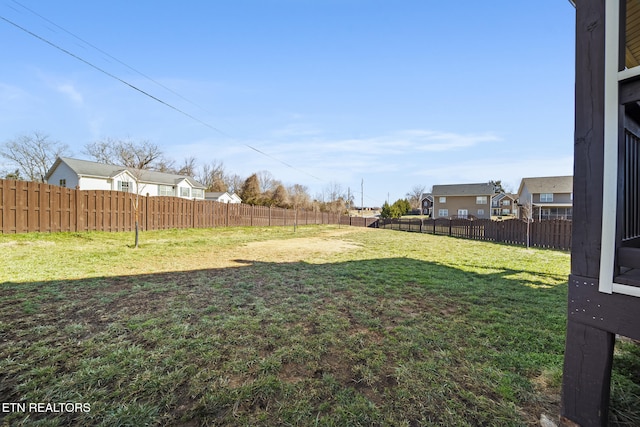 view of yard featuring a fenced backyard and a residential view