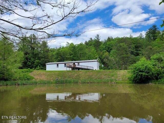 exterior space featuring a water view and a wooded view