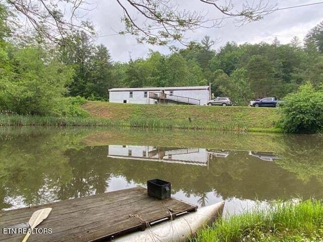 view of dock featuring a water view and a wooded view