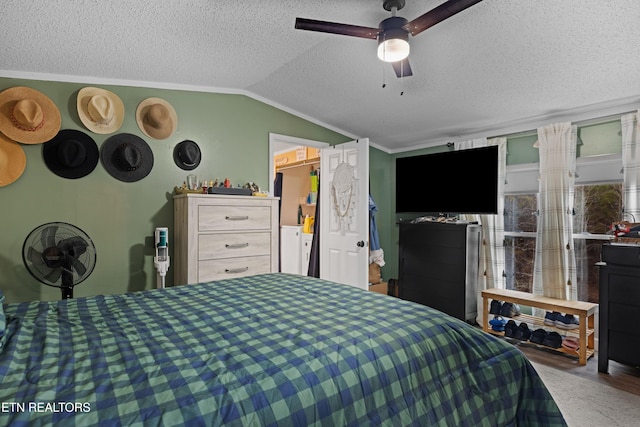 bedroom with crown molding, vaulted ceiling, a textured ceiling, and ceiling fan