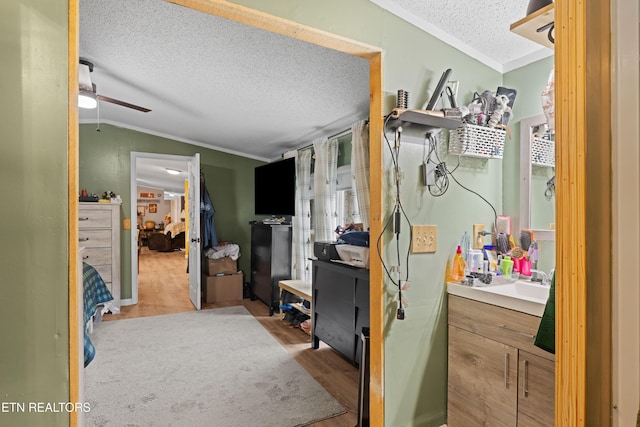 bathroom featuring lofted ceiling, crown molding, a textured ceiling, and wood finished floors