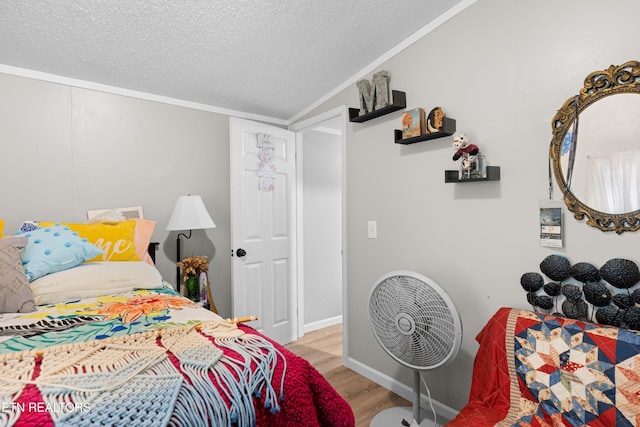 bedroom with a textured ceiling, crown molding, wood finished floors, and lofted ceiling