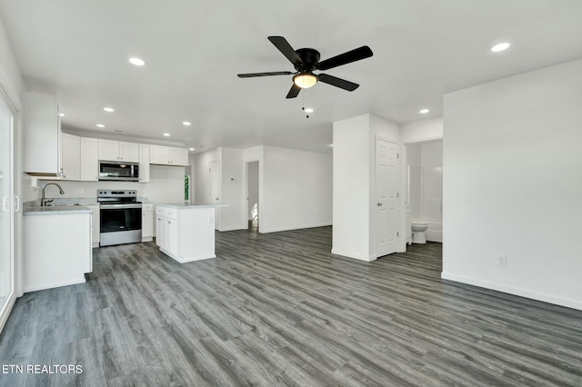 kitchen featuring recessed lighting, white cabinetry, stainless steel appliances, and open floor plan