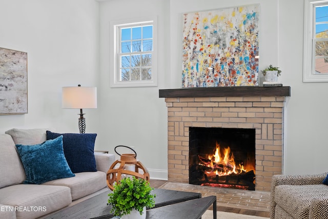 living room with baseboards and a brick fireplace