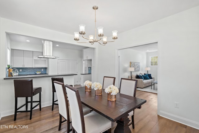 dining room featuring baseboards, wood finished floors, a chandelier, and recessed lighting
