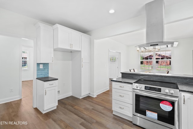kitchen featuring island range hood, dark countertops, and electric range