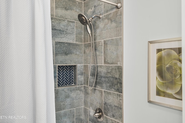 interior details featuring a tile shower