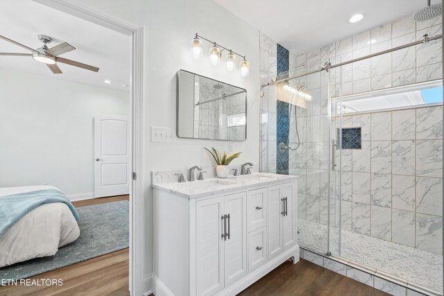 full bathroom with wood finished floors, a sink, a shower stall, and ceiling fan