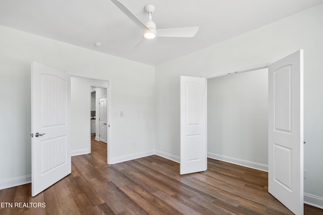 unfurnished bedroom with dark wood-type flooring, ceiling fan, and baseboards