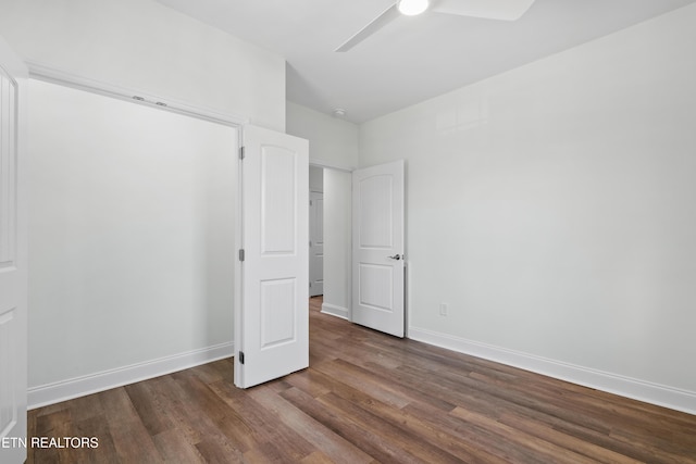 unfurnished bedroom featuring dark wood-type flooring, baseboards, and ceiling fan