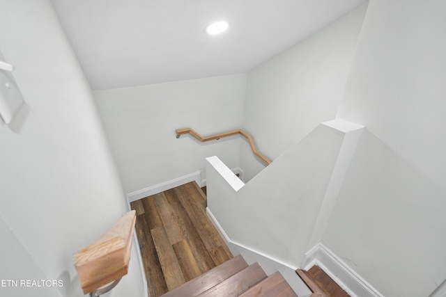 stairs featuring baseboards, wood finished floors, and recessed lighting