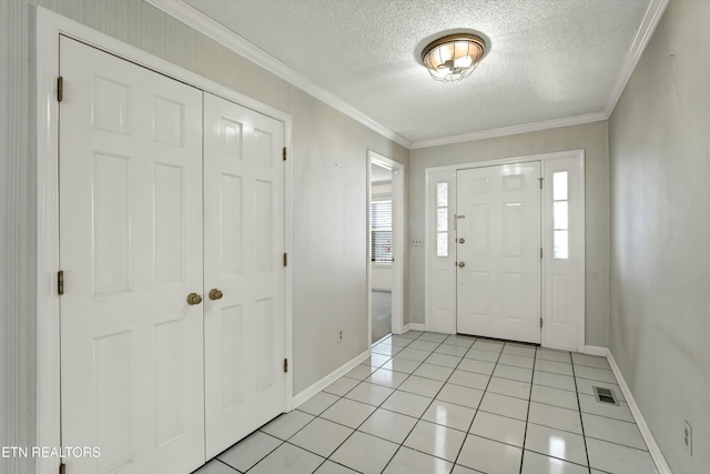 entrance foyer with light tile patterned floors, visible vents, a textured ceiling, and ornamental molding