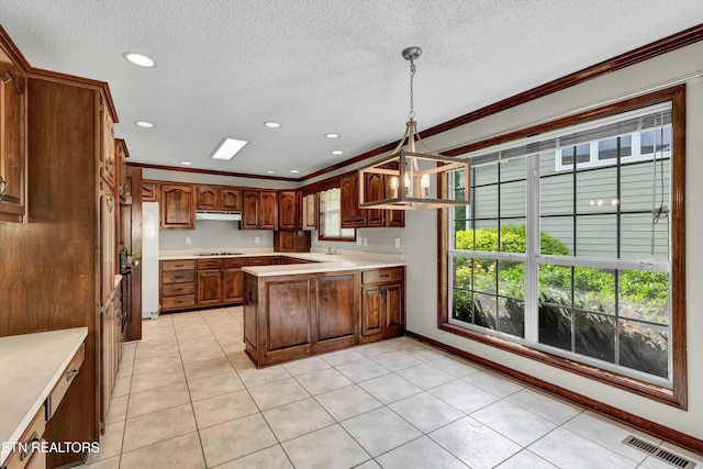 kitchen featuring a peninsula, visible vents, light countertops, and stovetop