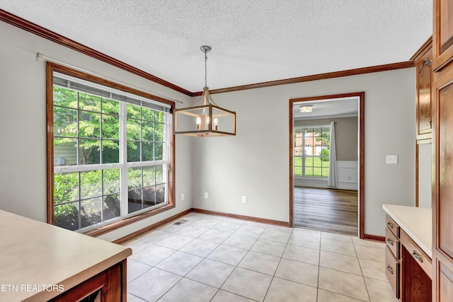 dining space with a notable chandelier, a textured ceiling, light tile patterned flooring, and crown molding