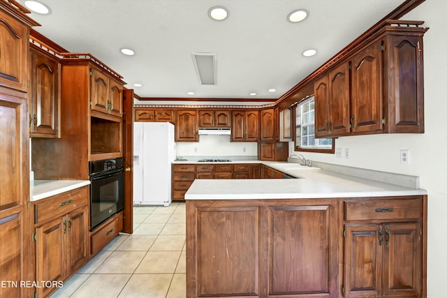 kitchen featuring oven, under cabinet range hood, white refrigerator with ice dispenser, a sink, and cooktop