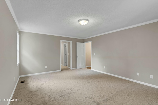 unfurnished room with ornamental molding, baseboards, visible vents, and carpet flooring