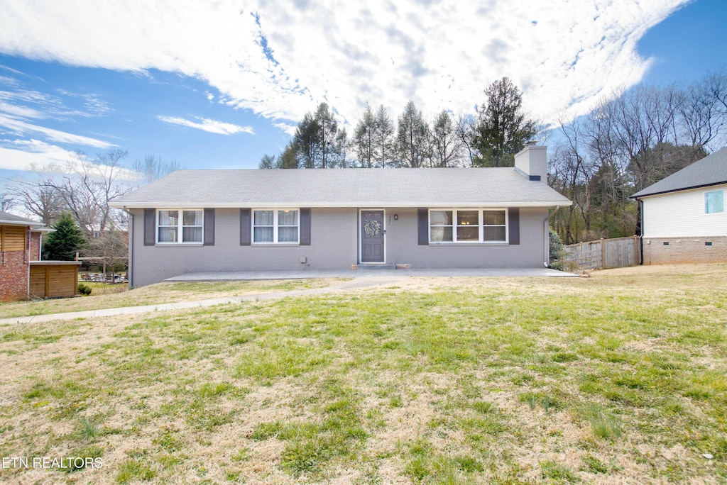 single story home featuring a chimney, fence, and a front lawn